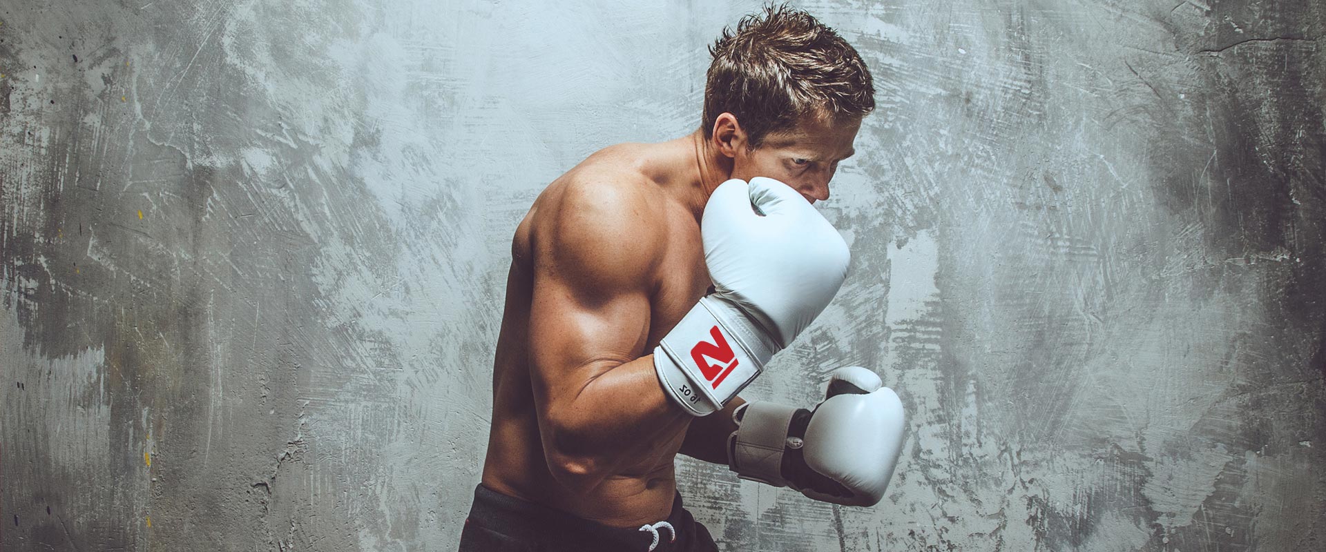 Ein Boxer mit weißen Handschuhen holt zum Schlag aus